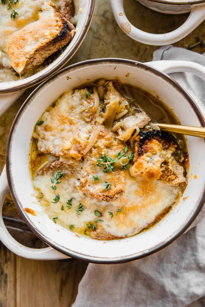 Cozy bowl of Vegetarian French Onion Soup with bread and cheese on top.