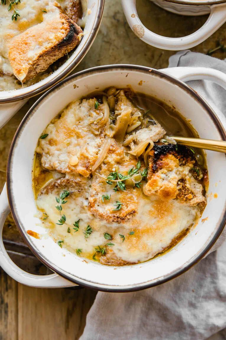 Cozy bowl of Vegetarian French Onion Soup with bread and cheese on top.