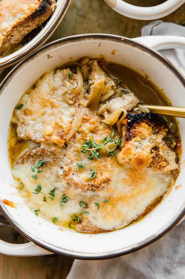 Spoon in a bowl full of Vegetarian French Onion Soup with lentils.