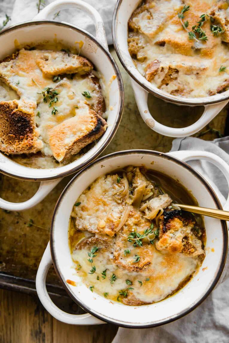 3 bowls with handles full of Vegetarian French Onion Soup, lentil, cheese and bread.
