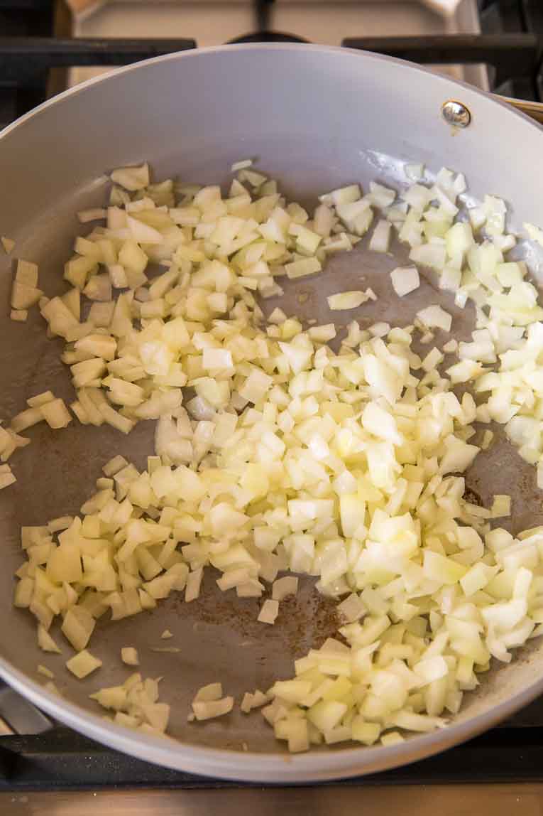 Onions being cooked in a pan.