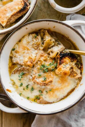 Cozy bowl of Vegetarian French Onion Soup with bread and cheese on top.