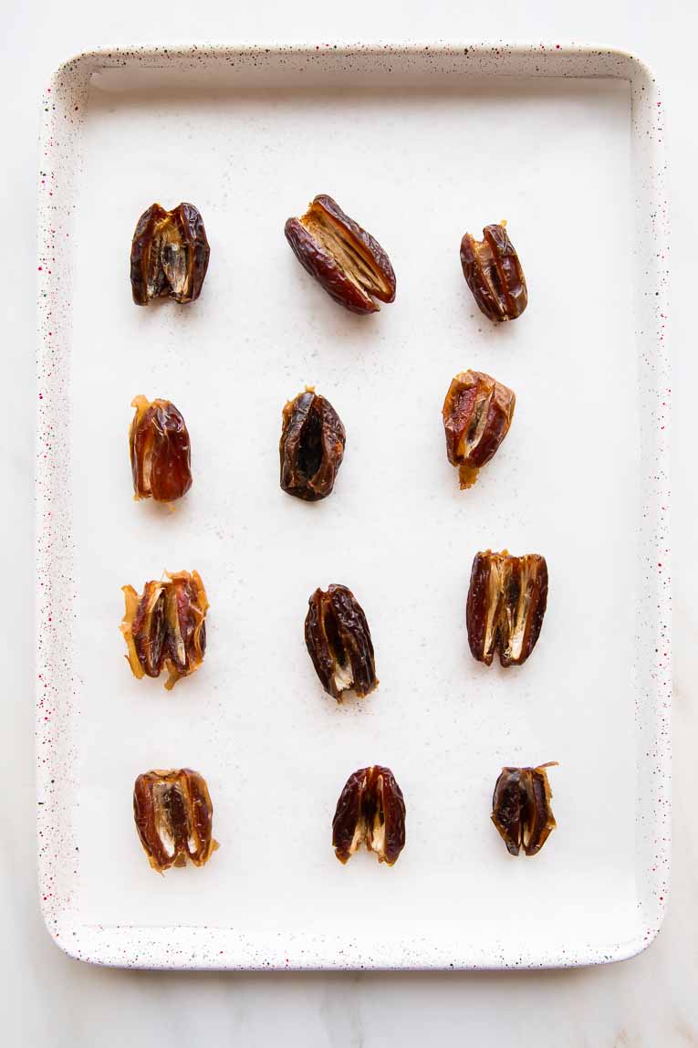 Dates soaked and pitted on a baking sheet.