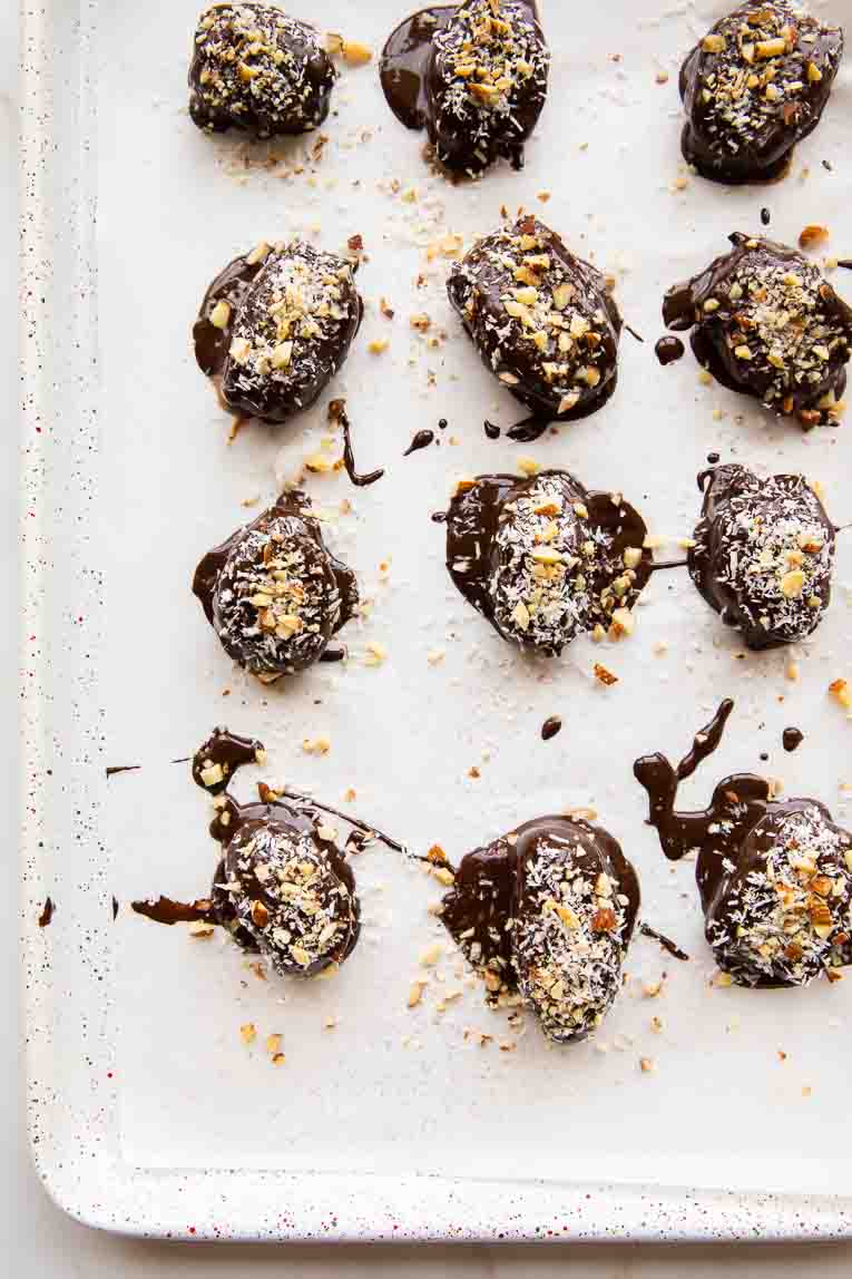 Chocolate covered dates on a baking sheet.