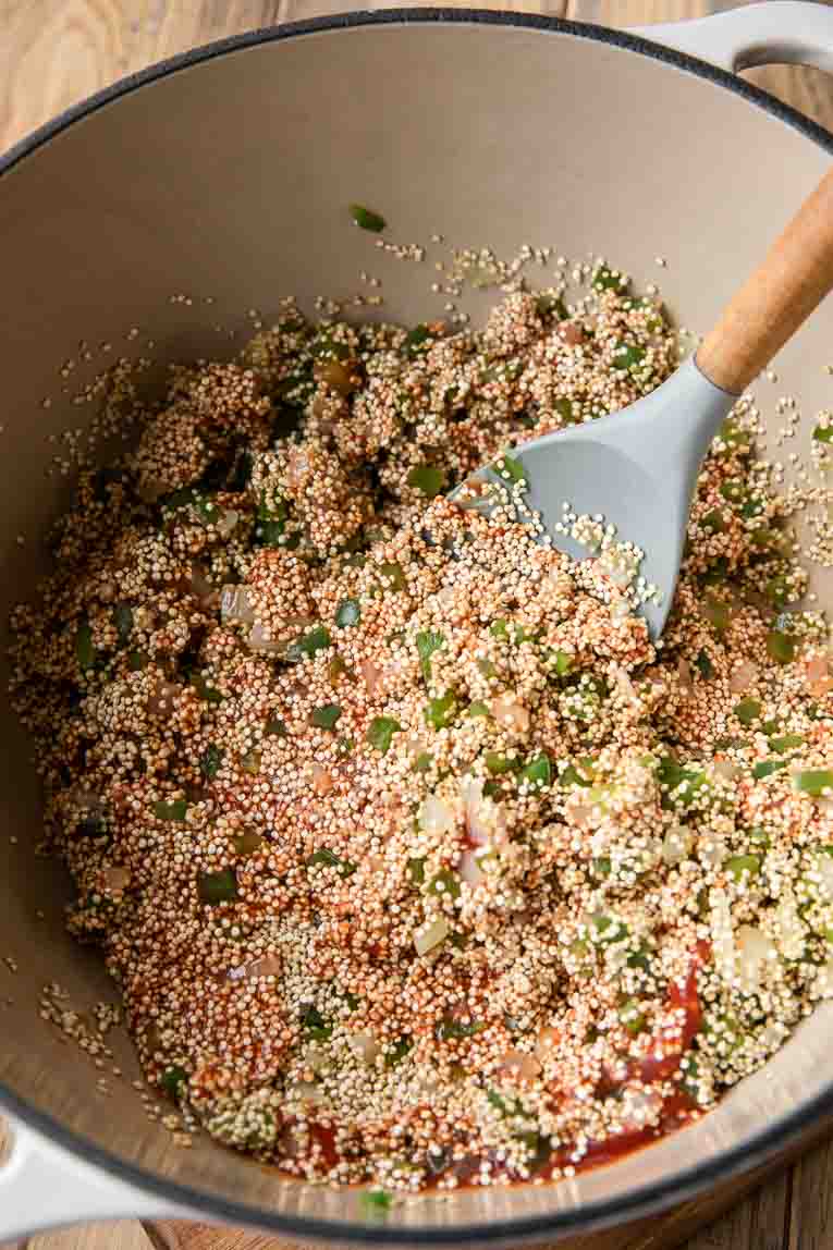 Quinoa and seasoning added in to dutch oven.