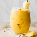 Golden Glow Pineapple Turmeric Smoothie recipe on a wooden table.
