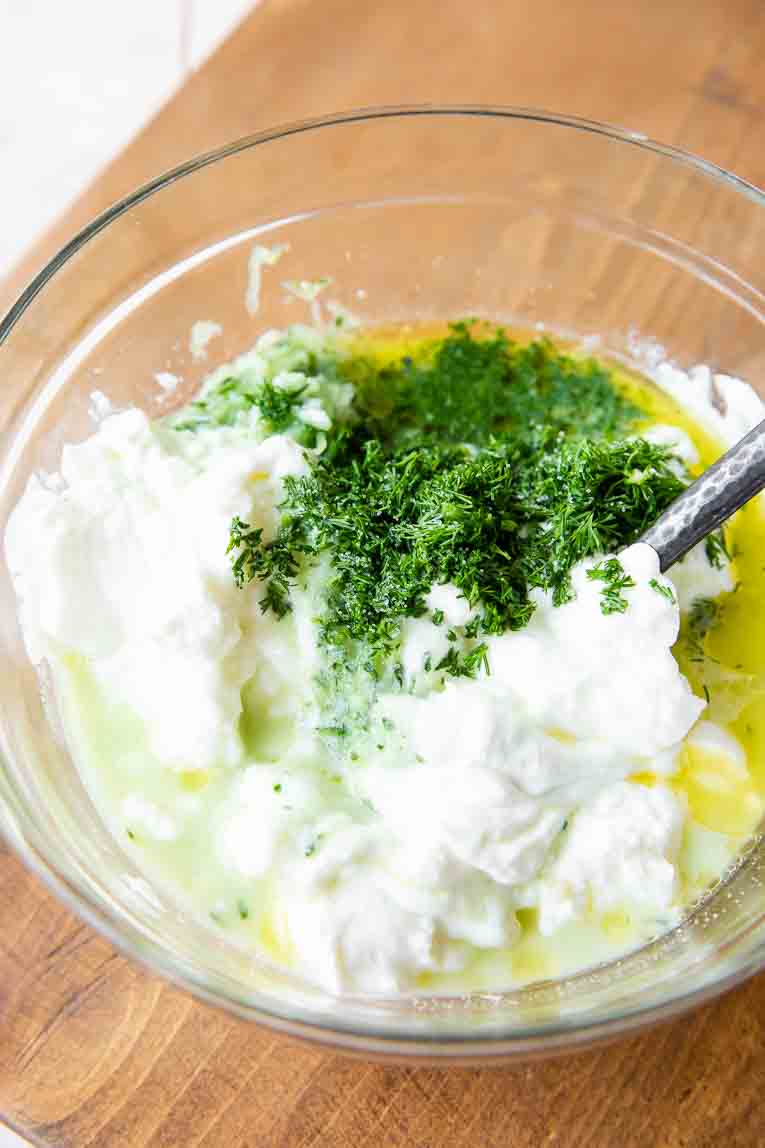 Tzatziki sauce being mixed together.