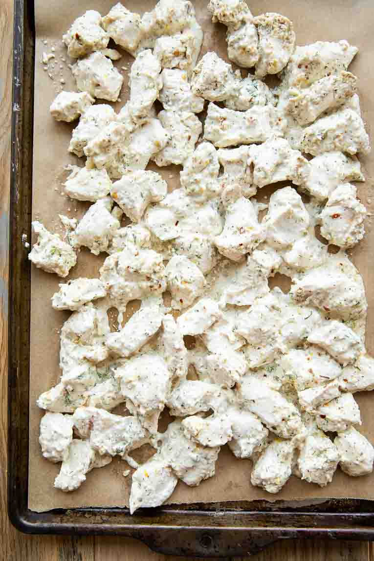 Marinated Greek chicken on a sheet pan.