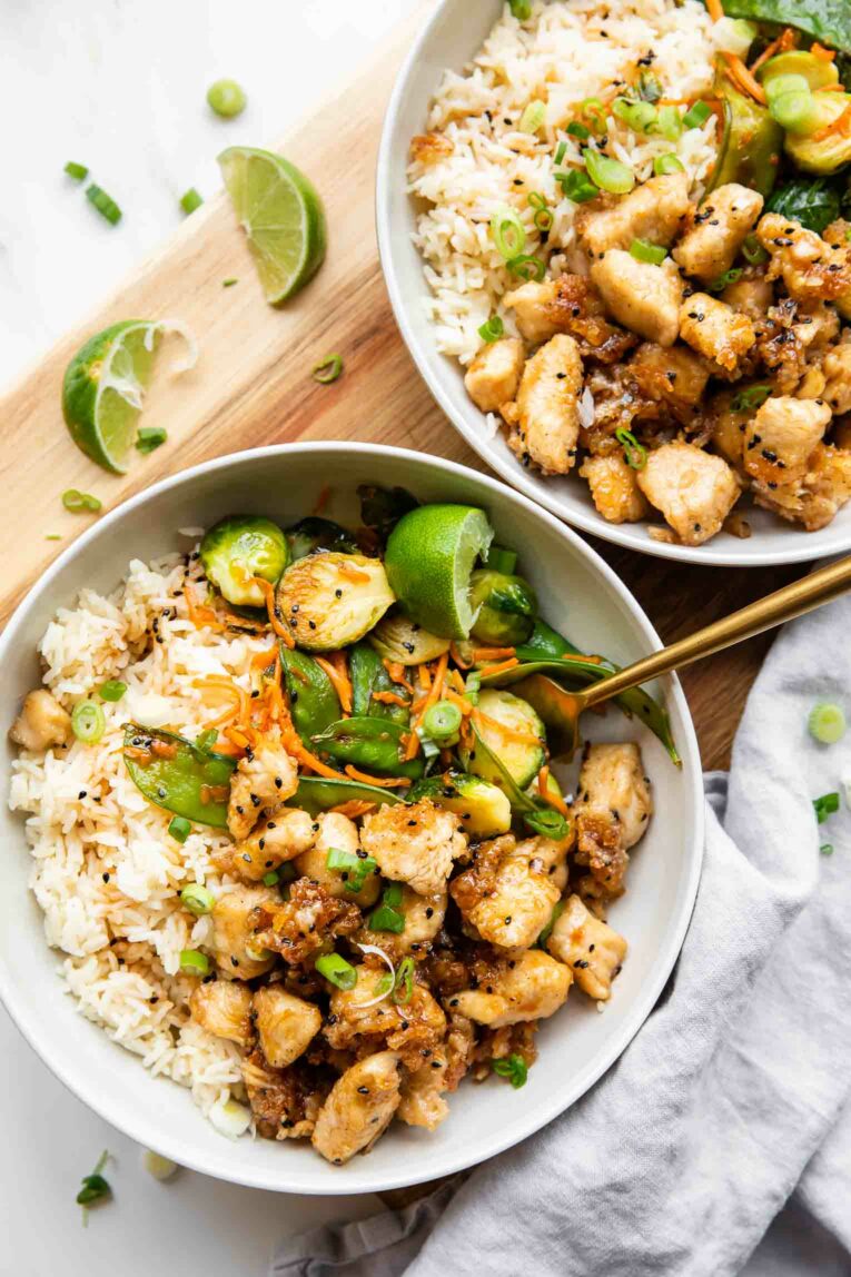 Two Honey Sesame Chicken Meal Prep Bowls with a fork.