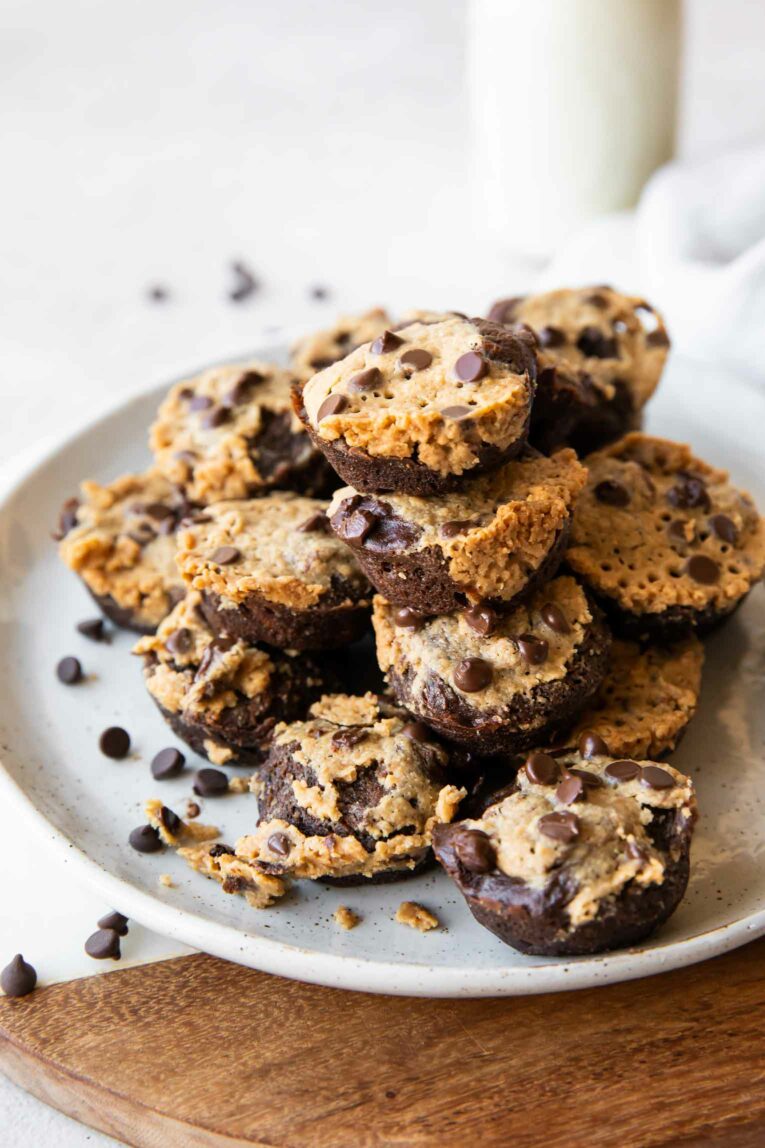 Angled photo of mini brownie bites on a plate with chocolate chips.