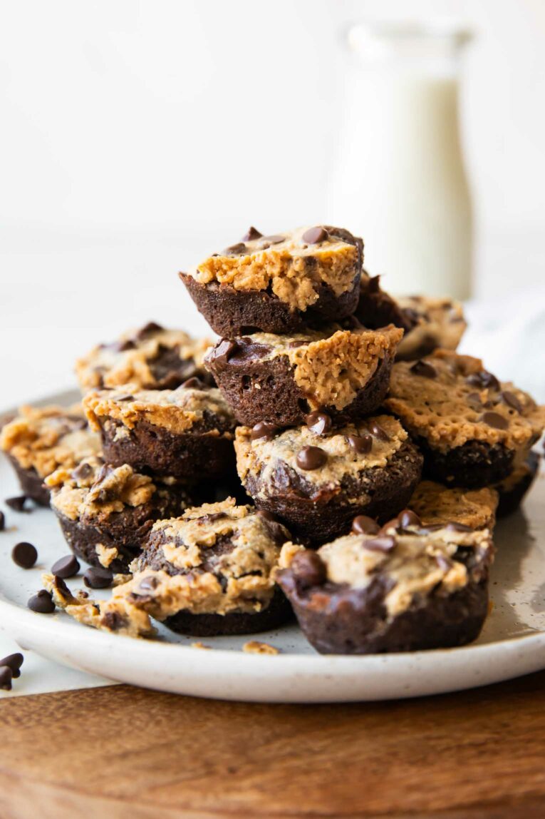 Protein Brownie Bites recipe stacked on a plate with milk in background.