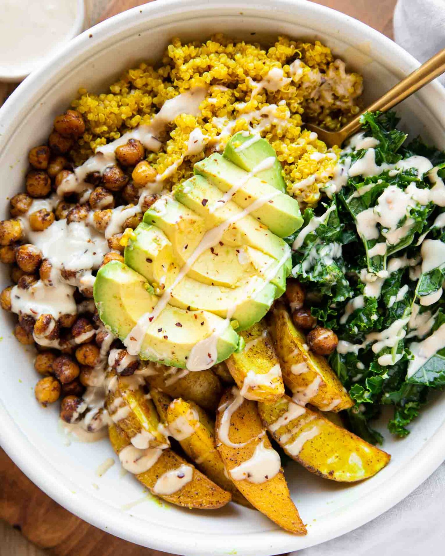 Vegan Turmeric Quinoa Power Bowl with avocado and dressing.