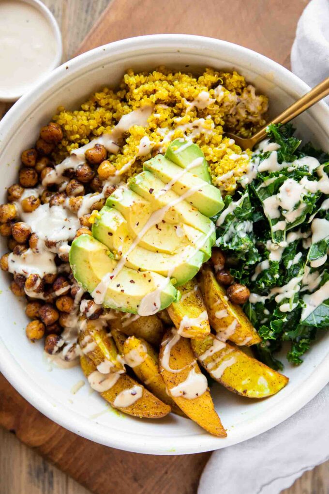 Vegan Turmeric Quinoa Power Bowl with avocado and dressing.