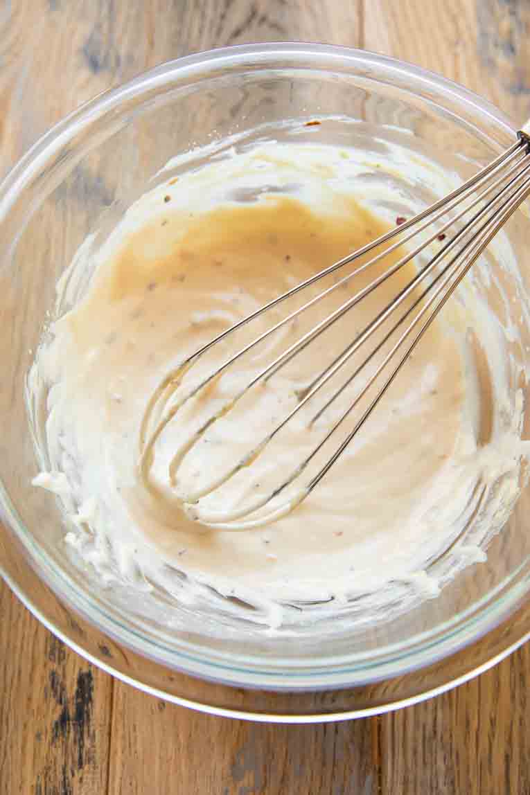 Tahini lemon dressing being whisked.