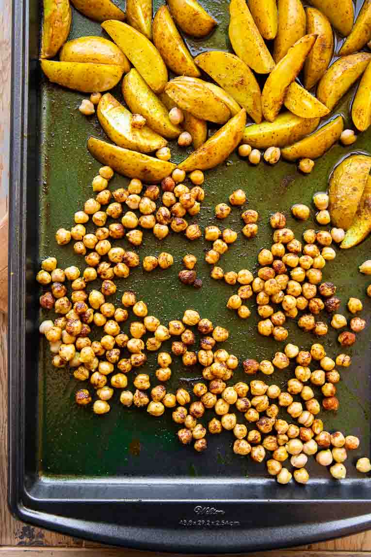 Chickpeas roasting on a pan with turmeric potatoes.