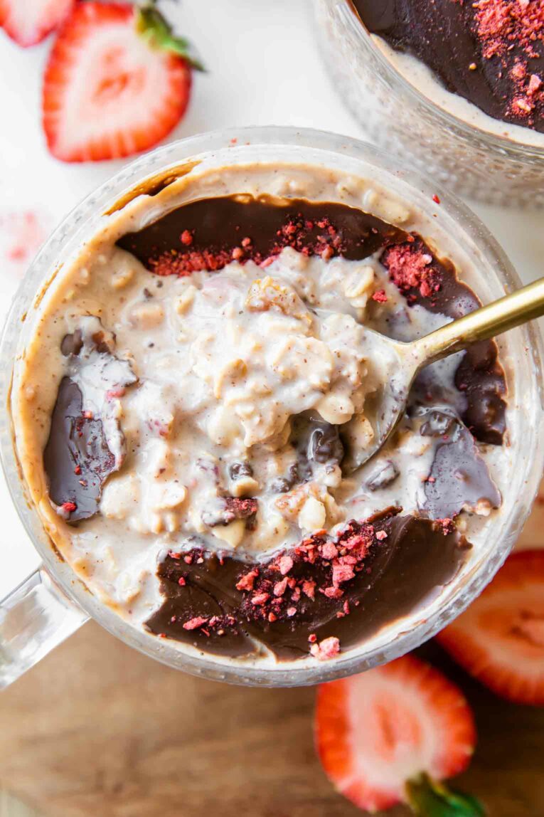 Strawberry oats with chocolate magic shell and spoon.