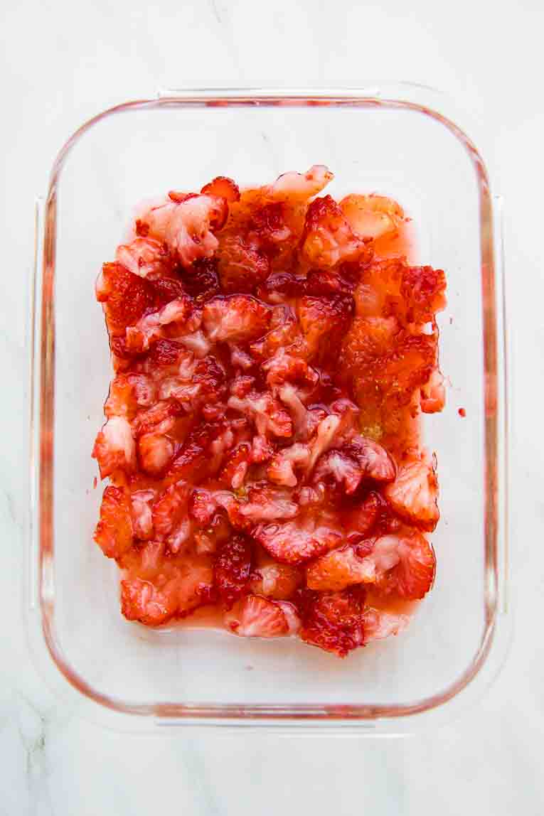 Mashed strawberries in a glass container.