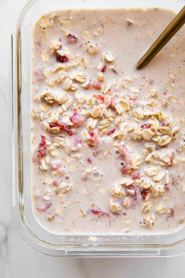 Strawberry overnight oats mixed in a glass container.