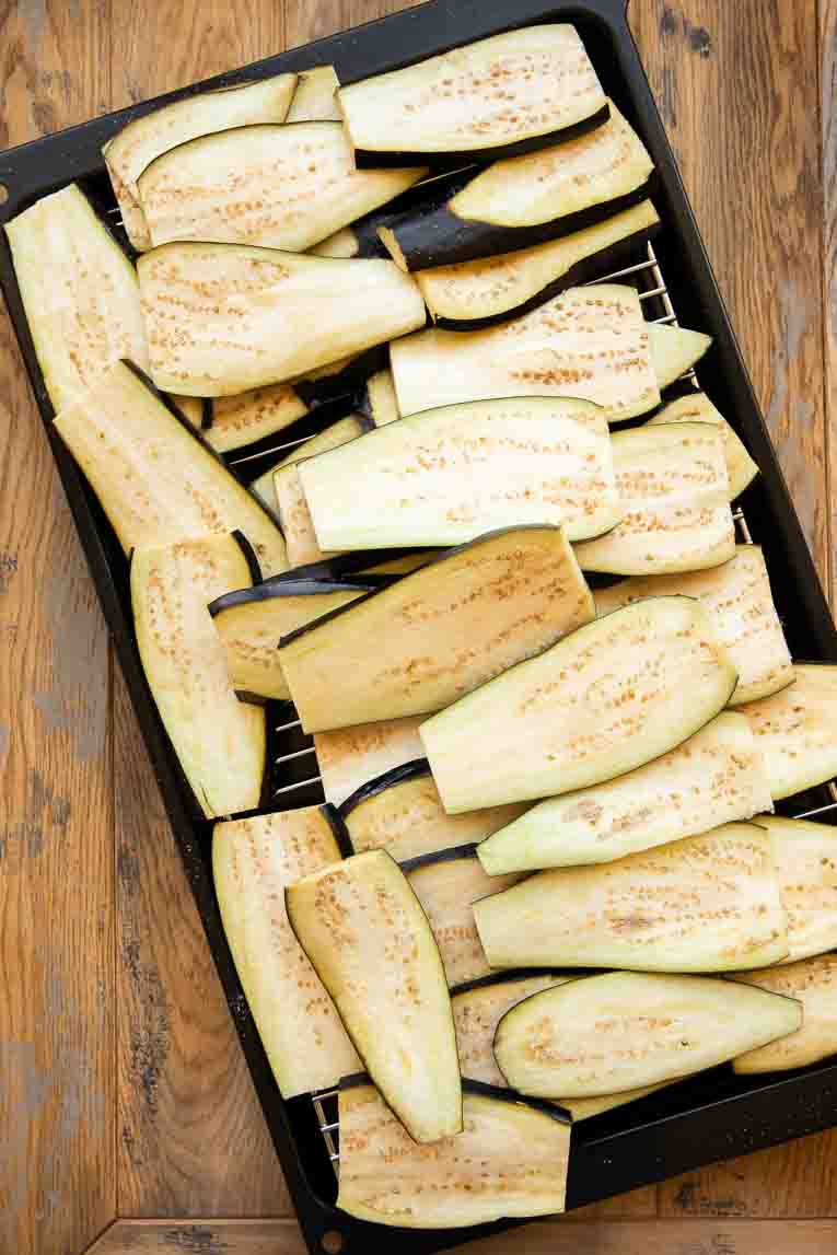 Eggplant sliced and on a roasting pan.