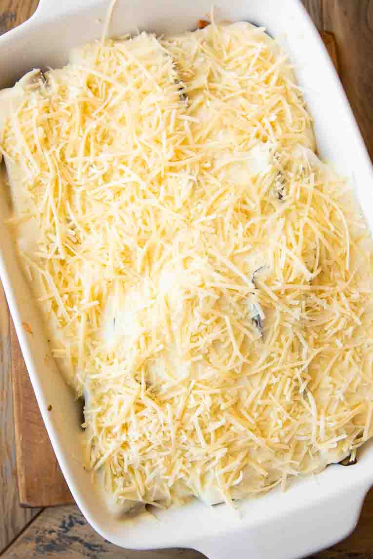 Bechamel sauce and parmesan in casserole dish over eggplant.