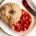 Homemade Gluten-Free Bagel sliced in half and topped with jam.