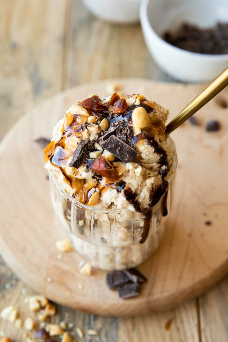 Angled photo of protein ice cream with Snickers toppings.