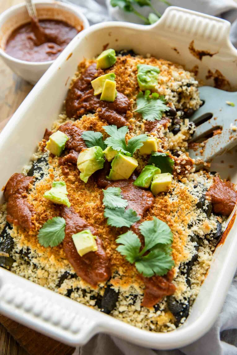 Angled photo of casserole dish with Chile Relleno Casserole recipe and sauce.