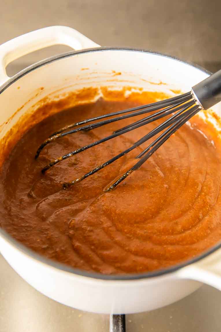 Sauce being cooked and whisked for Chile Relleno Casserole recipe.