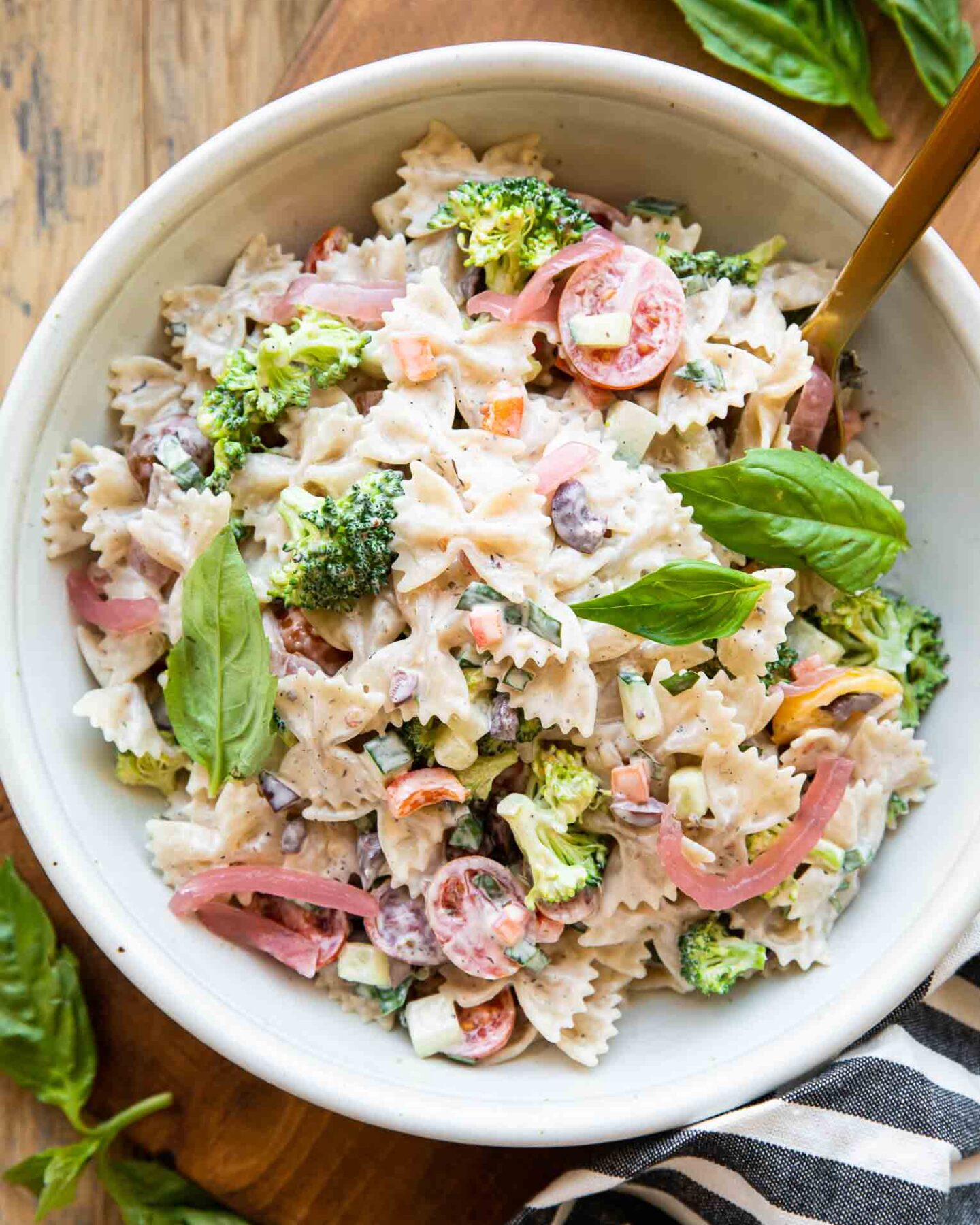 Creamy Vegan Pasta Salad in a bowl with a fork and basil.