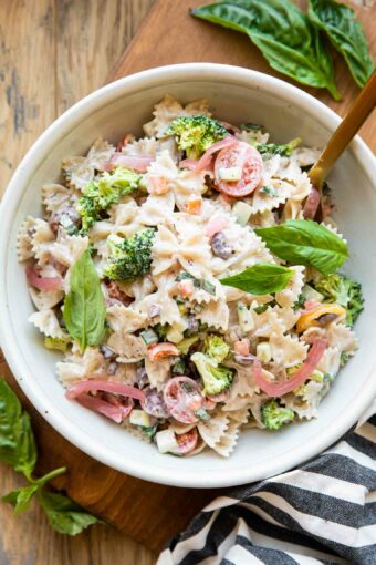 Creamy Vegan Pasta Salad in a bowl with a fork and basil.