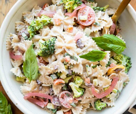Creamy Vegan Pasta Salad in a bowl with a fork and basil.