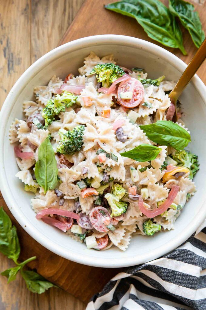 Creamy Vegan Pasta Salad in a bowl with a fork and basil.