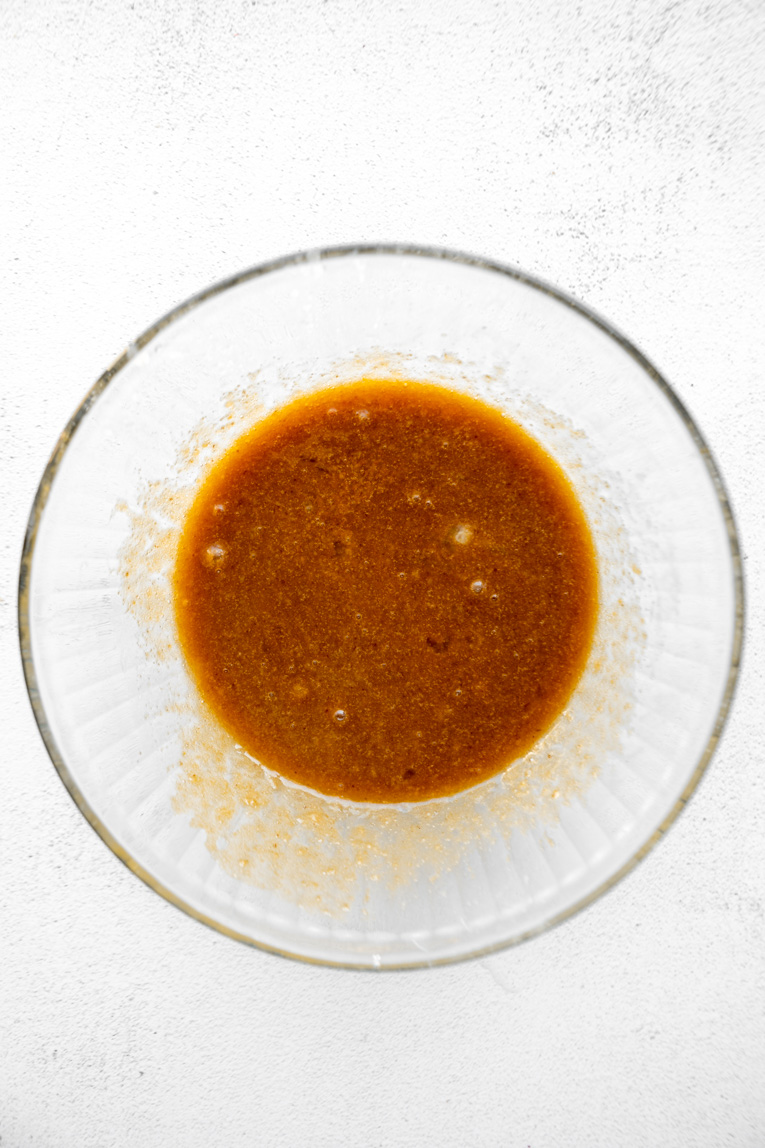 Liquid ingredients for carrot cake mixed in a bowl.