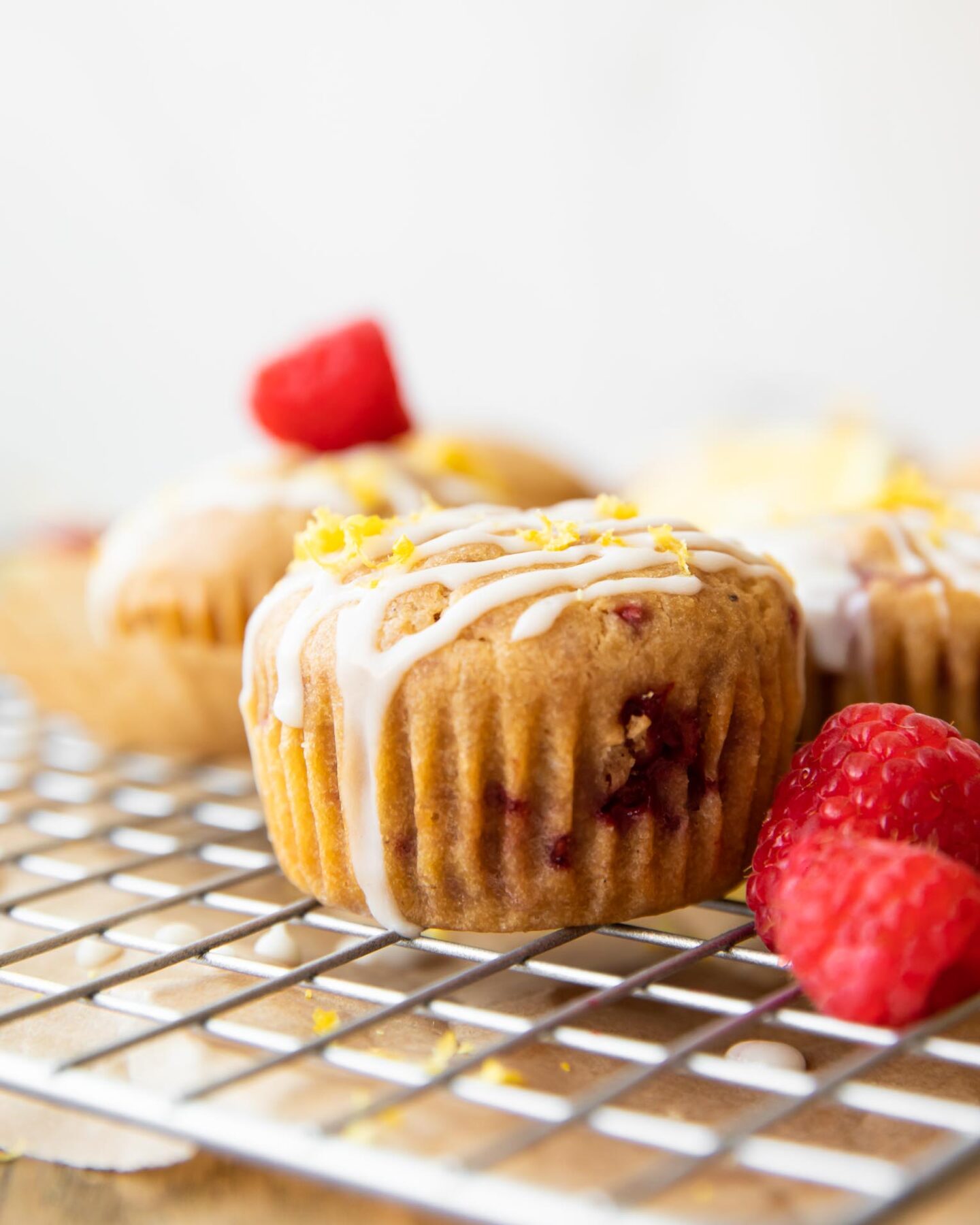 Across photo of a Gluten-Free Lemon Raspberry Muffin on a cooling rack.