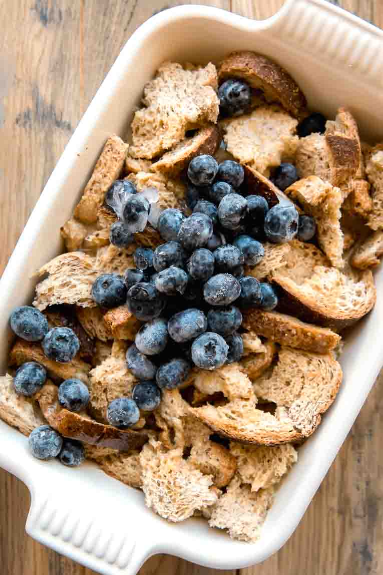 Egg mixture poured over bread with blueberries.