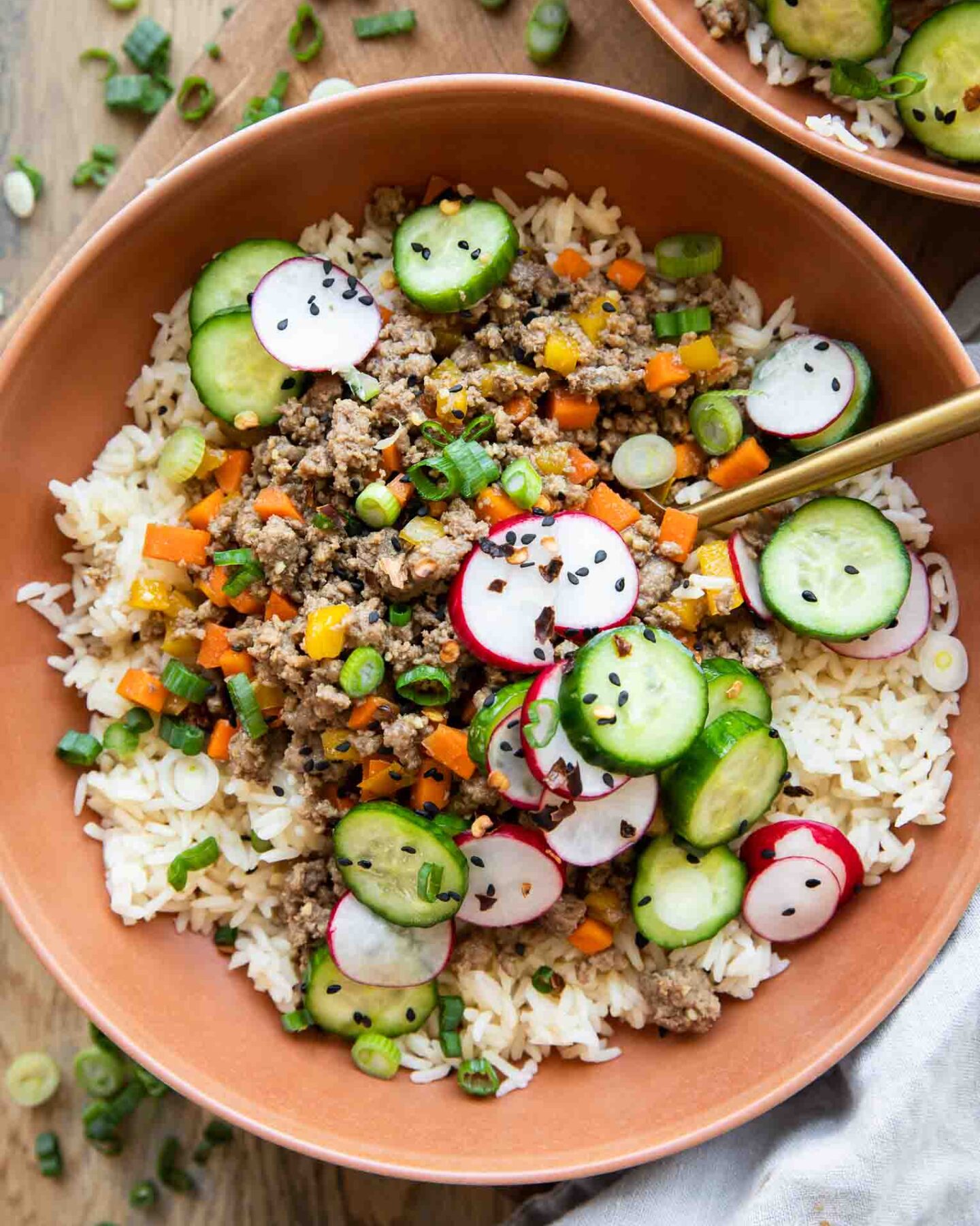 Korean Beef Bowls recipe with radishes and cucumbers.