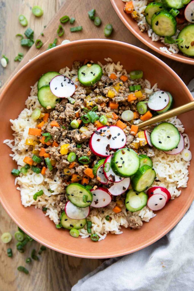 Korean Beef Bowls recipe with radishes and cucumbers.