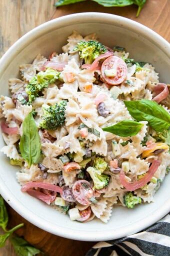 Creamy Vegan Pasta Salad recipe in a white bowl with fresh basil.