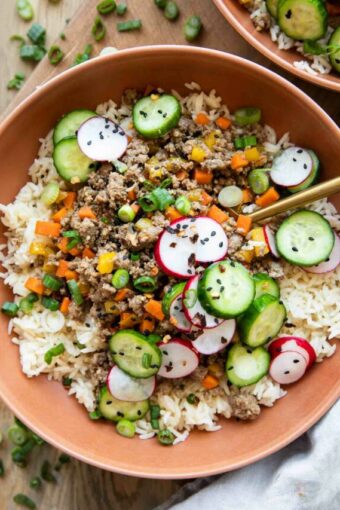 Korean Beef Bowls recipe with radishes and cucumbers.