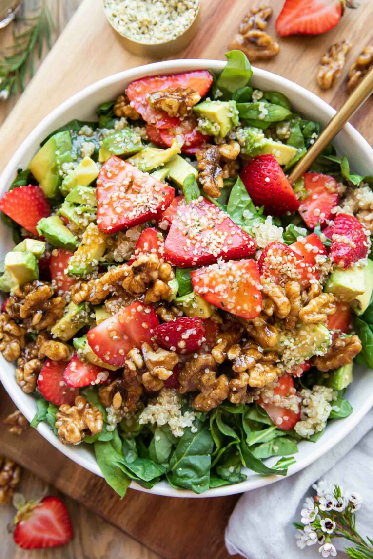 Strawberry Spinach Salad recipe in a bowl with avocados, walnuts, and hemp seeds!