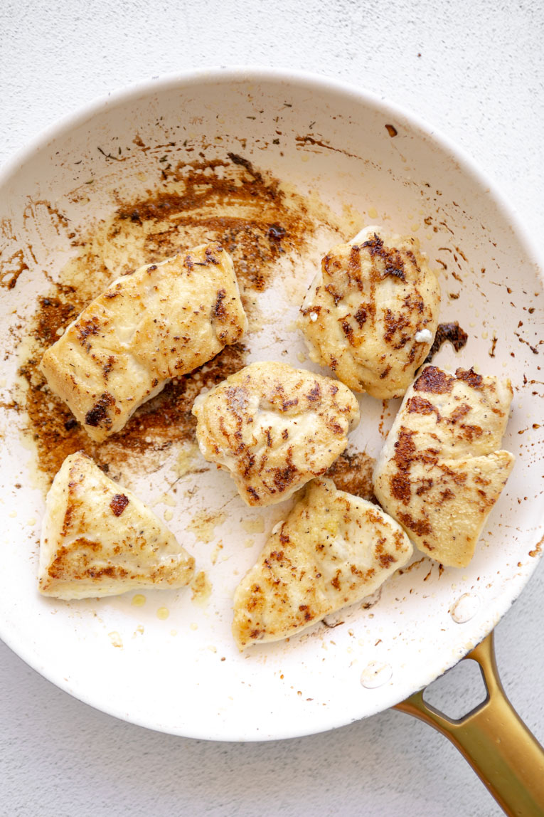 Chicken being cooked in a skillet.