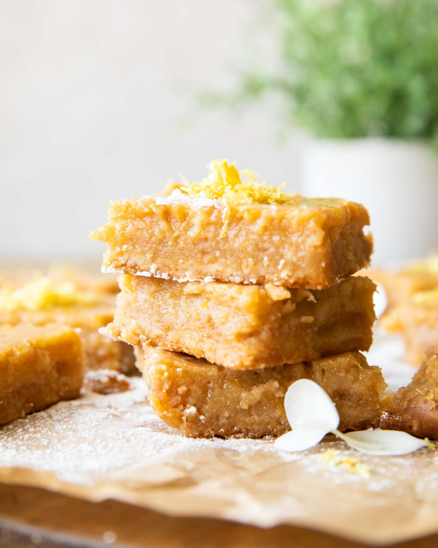 Gluten-Free Lemon Bars stacked with lemon zest on top.