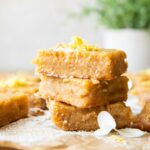 Gluten-Free Lemon Bars stacked with lemon zest on top.