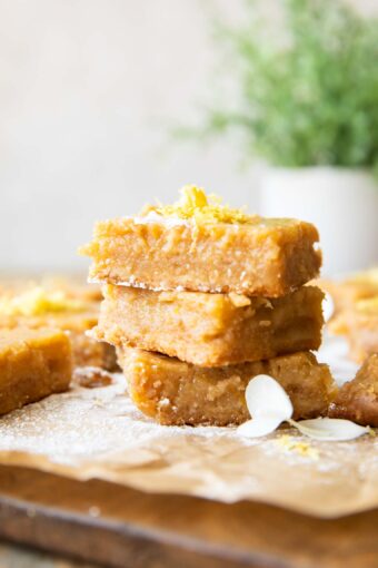 Gluten-Free Lemon Bars stacked with lemon zest on top.