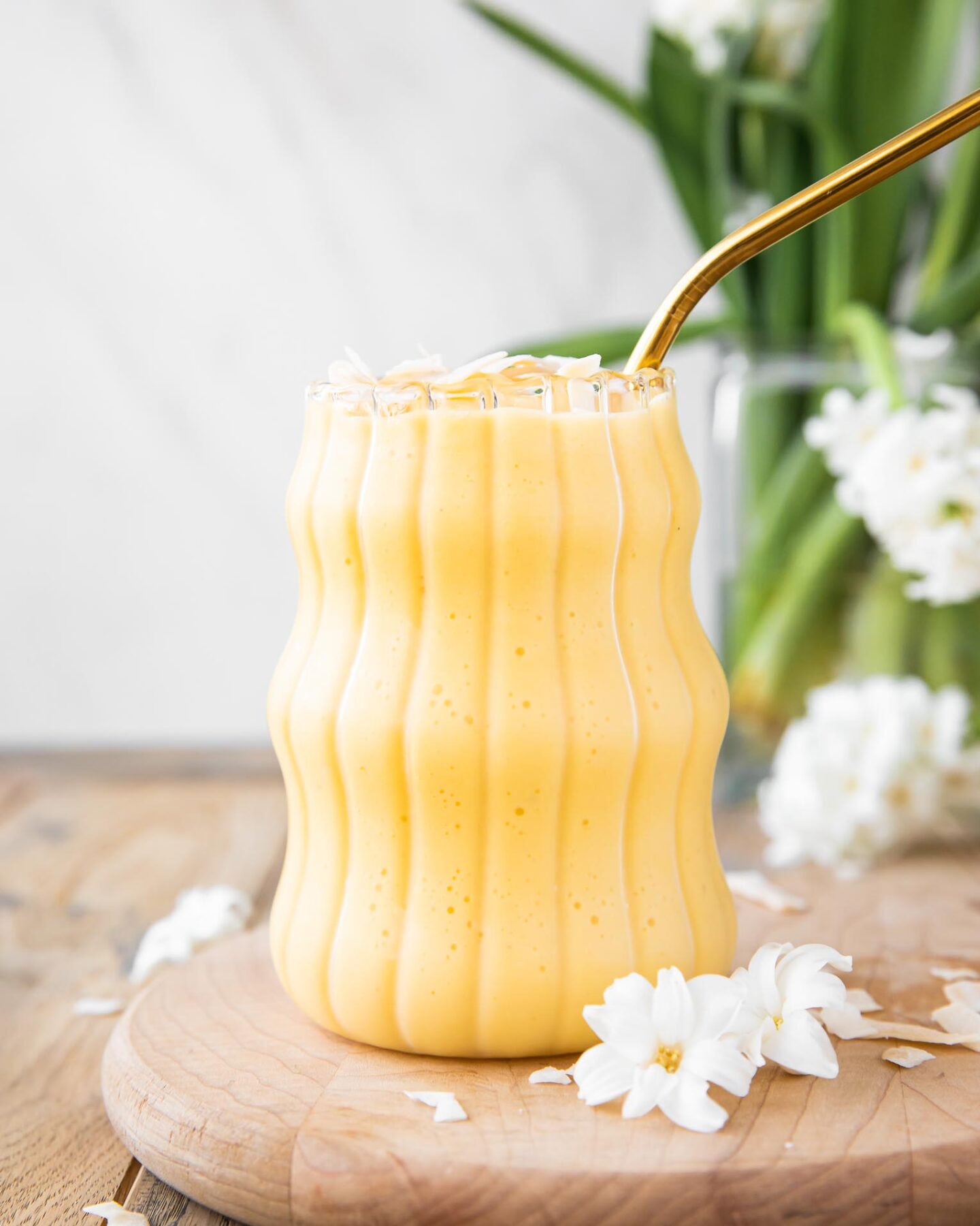Healthy Mango Banana Smoothie on a wood board.