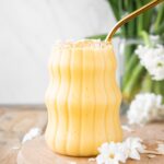 Healthy Mango Banana Smoothie on a wood board.
