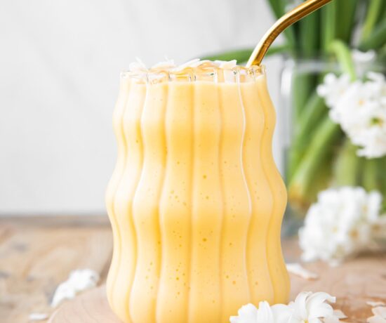 Healthy Mango Banana Smoothie on a wood board.