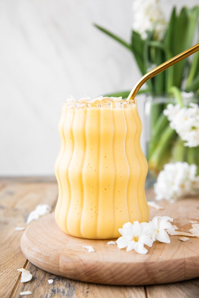 Healthy Mango Banana Smoothie on a wood board.