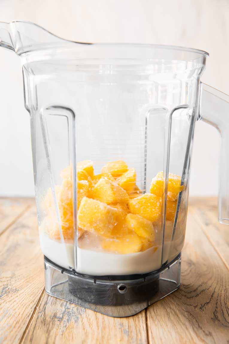 Ingredients for mango smoothie recipe in a blender.