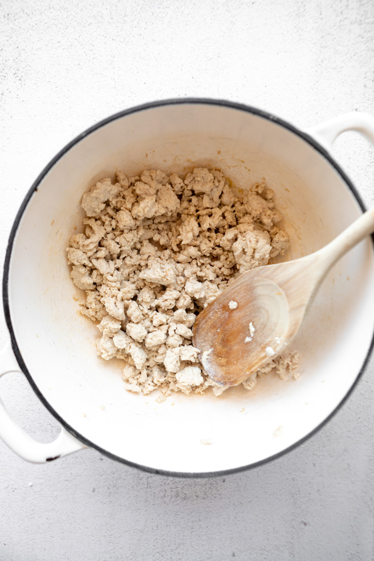Ground turkey being cooked in a dutch oven.